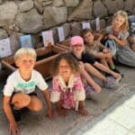Førsteklasses grønnsakshage - bilder av barna sittende foran pottene med grønnsaker